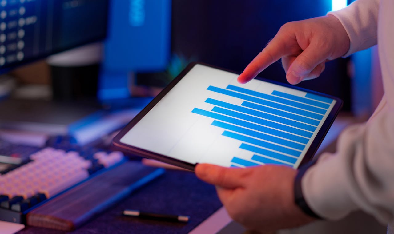about-01 Business professional analyzing bar chart on tablet in office setting, highlighting data insights.